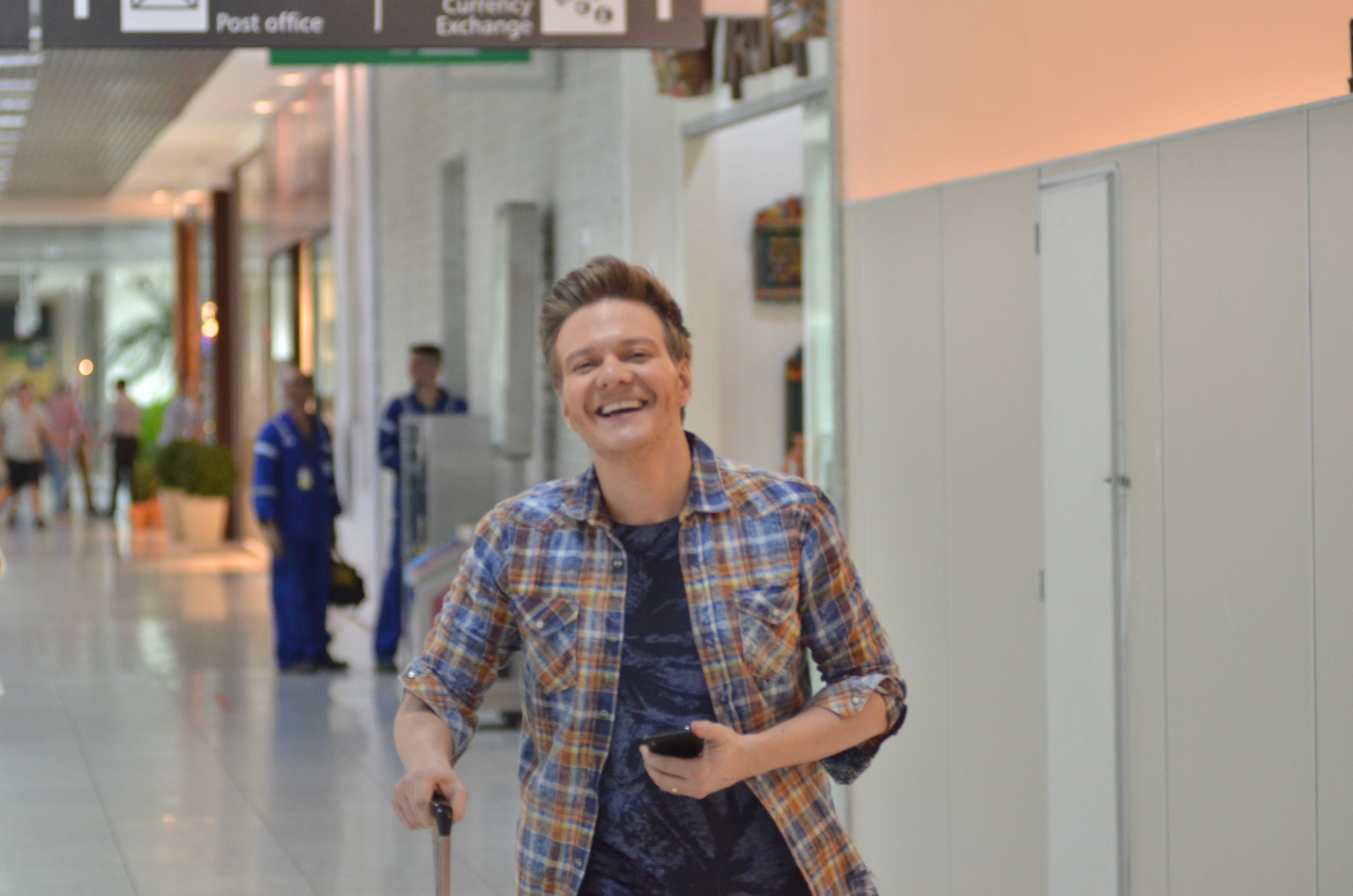 Vai dar uma fugidinha! Michel Teló é flagrado sorridente em aeroporto