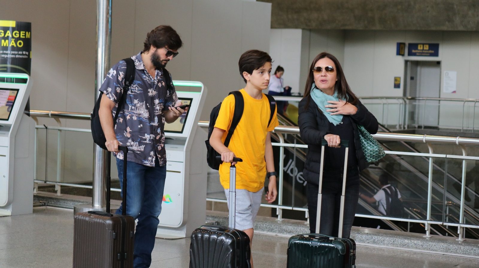 Adriana Esteves e Vladimir Brichta embarcam com o filho em aeroporto no Rio