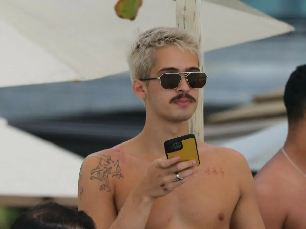 Sem camisa, João Guilherme é clicado comendo milho em praia carioca