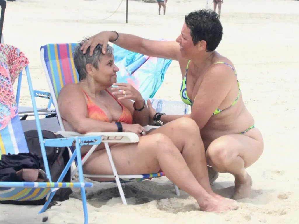 Após internações, Claudia Rodrigues é vista feliz aos beijos com namorada em praia carioca